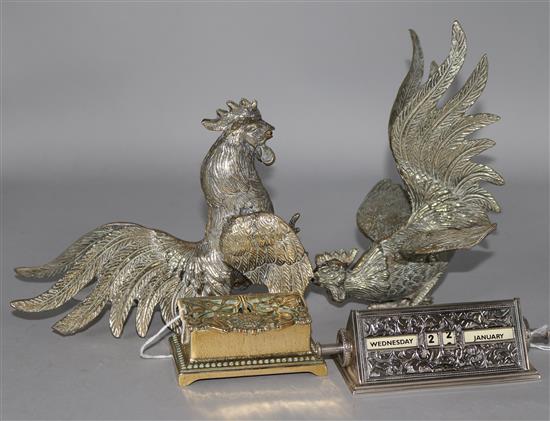 Two plated fighting cocks, a plated desk calendar and a brass stamp box